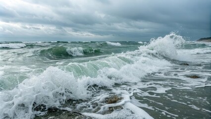 Fototapeta premium Powerful ocean waves crashing on the shore under a dramatic stormy sky