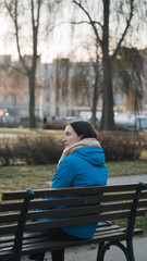 Solitary woman enjoying a quiet park atmosphere. Lifestyle photography with a reflective moment in a city park during winter in a outdoor park setting.