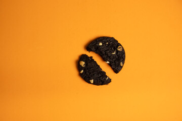 Naklejka premium Broken chocolate cookie on a colored background