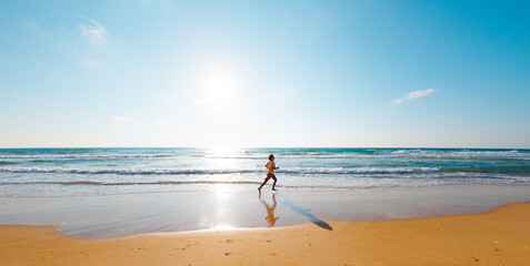 Active man jogging. Healthy lifestyle. a man runs barefoot along the beach by the sea. A young...