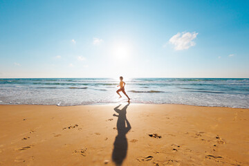 Active man jogging. Healthy lifestyle. a man runs barefoot along the beach by the sea. A young...