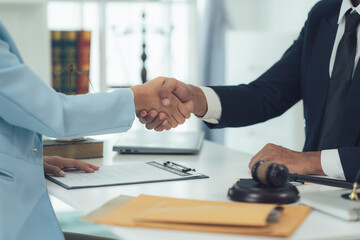 A Handshake of Justice:  A lawyer and client shake hands, symbolizing trust, agreement, and the...