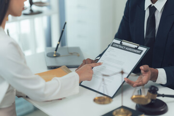 Contract Agreement: A close-up shot of a lawyer reviewing a contract agreement with a client, emphasizing the importance of legal consultation and careful document review.  