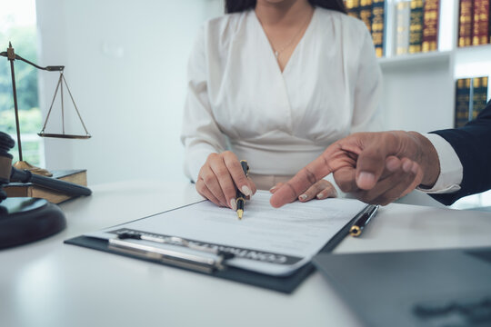 Legal Consultation:  A lawyer guides a client through important documents, signifying trust and expertise in a professional setting.