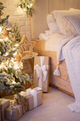 Bright modern bedroom decorated with fir garlands and Christmas trees. Interior in warm minimalism style.