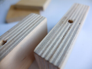 Wooden furniture parts and a bag of fittings for assembling furniture in a room against the wall.