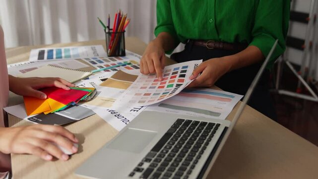 Slow motion hand closeup of two designer brainstorming and choosing color for graphic design working or client asking advise with chromatic consultation at designer agency office. Variegated