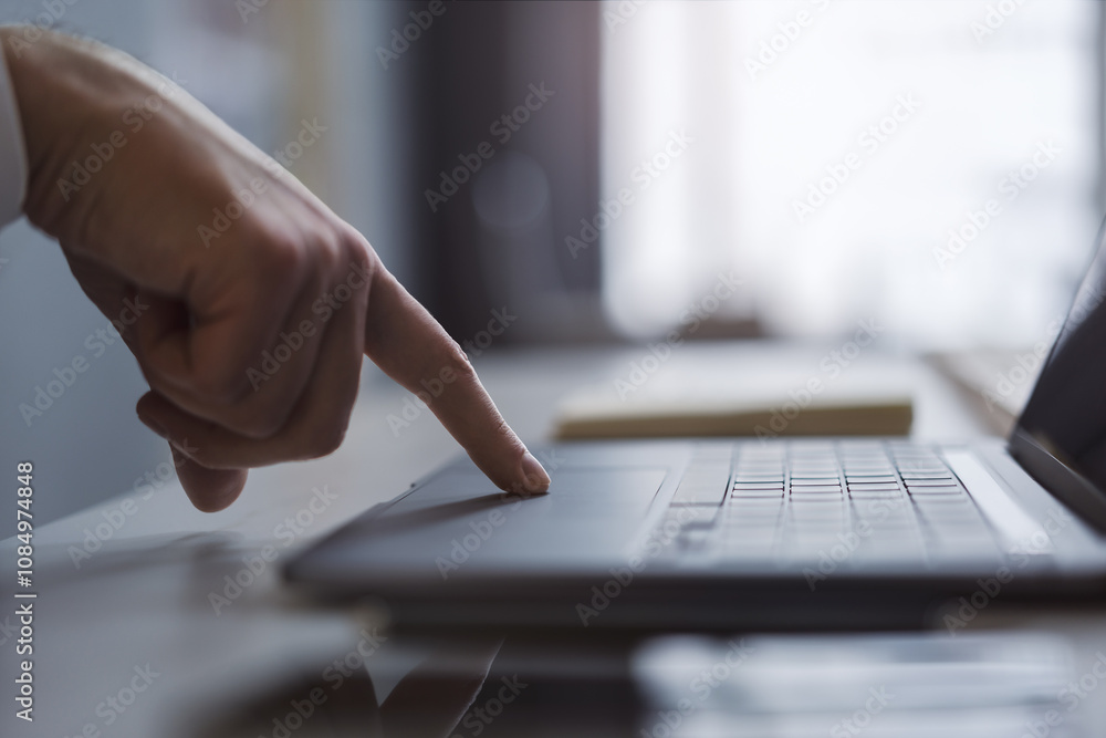 Poster The image captures a man's hands typing on a modern laptop keyboard, with the office setting in the background appearing blurred