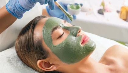 Gordijnen Relaxing Facial Treatment: Close-up of a woman receiving a luxurious facial treatment, with a green mask being applied gently. The image evokes a sense of calm, rejuvenation, and self-care.   © photostockatinat