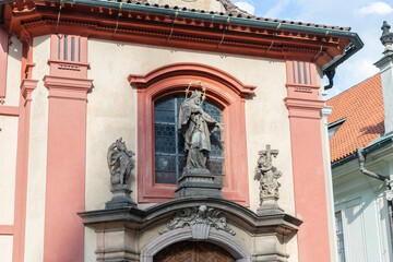 Statue of St John on facade St Georges Basilica in Third courtyard of Prague Castle near St Vitus Cathedral in Prague in Czech Republic
