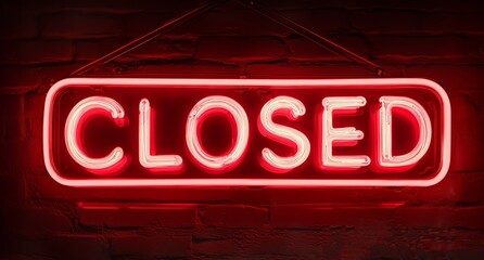 Red neon closed sign hanging on dark brick wall with glowing light effect