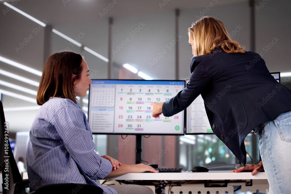 Poster mature businesspeople analyzing gantt chart and calendar on computer