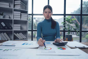 Focused Businesswoman Analyzing Data: A professional woman meticulously studies financial charts...