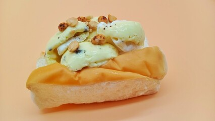 Peanuts topping on coconut and vanilla ice cream, bread and beige color background