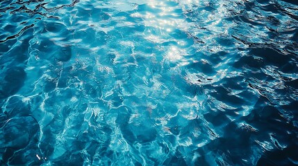 Obraz premium Blue water surface with ripples and reflections background