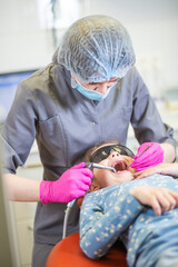 Professional dental treatment in a modern clinic with a caring dentist working on a young patient