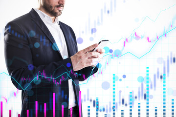 Businessman using a smartphone with international financial charts and graphs overlayed on a light background, representing economic growth.