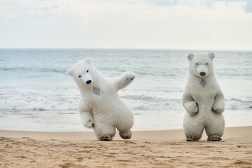 Animators dressed as polar bears entertain people on the beach. High quality photo