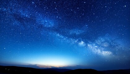 Fototapeta premium 深い青色の夜空に、星々が静かに輝く穏やかな夜の空が広がる背景。