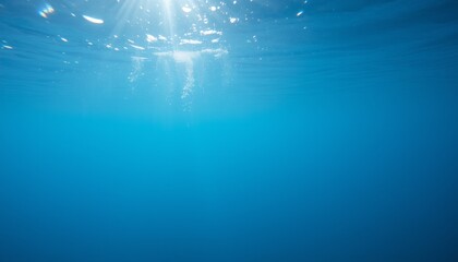 Obraz premium Underwater scene with bubbles and sunlight filtering through deep blue water.