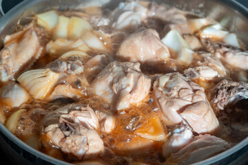 A spicy Korean chicken stew with potatoes, onions, and red chili-based sauce boiling in a pot.