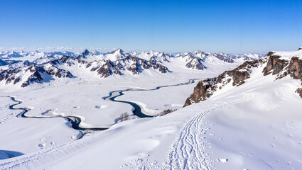 Snowy alpine valley with winding trails