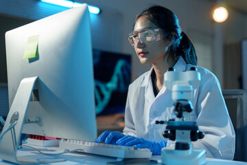 Asian female scientist holds a test tube filled with blue liquid in the laboratory. Examination....