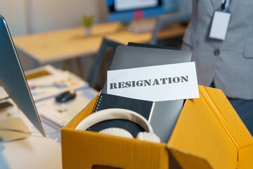 Asian female office worker is stressed, sad, packing up things, documents, personal items. Being...