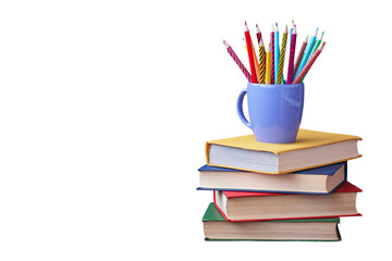 A colorful mug filled with pencils placed on a stack of books, ideal for study and creativity