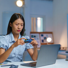 Confident Asian businesswomen sitting at their desks Are using banking applications to buy or pay online mobile bills. and registered her credit card on the website for online purchases.