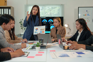 Financial analyst analyzes business finance reports on laptop and graph documents during corporate meeting discussions showing successful teamwork, business meeting ideas, marketing.