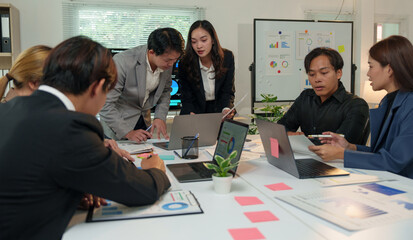 Financial analyst analyzes business finance reports on laptop and graph documents during corporate meeting discussions showing successful teamwork, business meeting ideas, marketing.