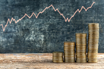 Golden coins stacked with financial growth chart in the background, symbolizing wealth, investment, cryptocurrency, and economic trends