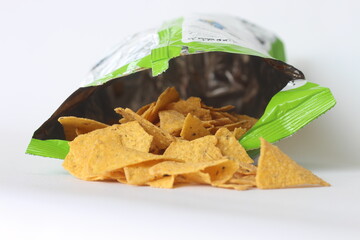 Pile of crispy corn chips in plastic packaging isolated on white background clipping path
