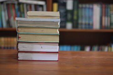 stack of books on wooden table against blurred background. space for text, education, school