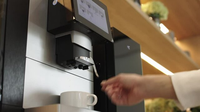Close-up of preparing aromatic coffee in a professional coffee machine. Concept of modern technology, small business and coffee drinks.