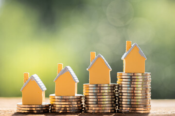 Home model put on top the stack gold coin  in the public park, Saving money for buy house or loan for plan business investment of real estate concept.