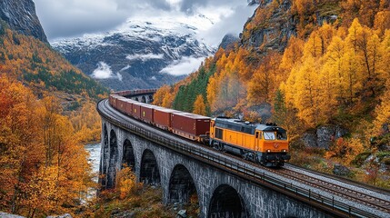 Fototapeta premium A train travels through a scenic autumn landscape with vibrant foliage and mountains.