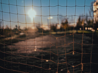 Soccer net with sunlight and field