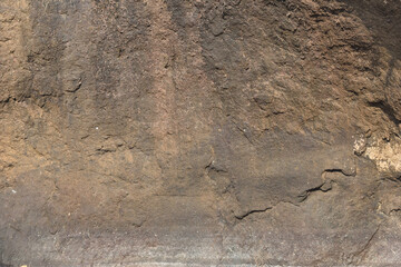 Close-up of a rough and textured rock surface. Raw stone surface showing organic shapes and lines. Earthy rock texture ideal for backgrounds or designs.