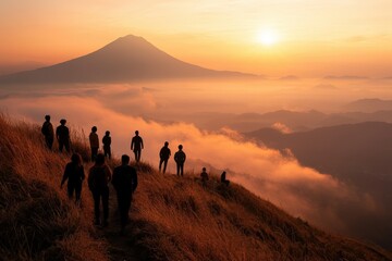 Fototapeta premium Hikers silhouetted against a breathtaking sunrise over a misty mountain range, capturing the serenity and adventure of exploring nature.