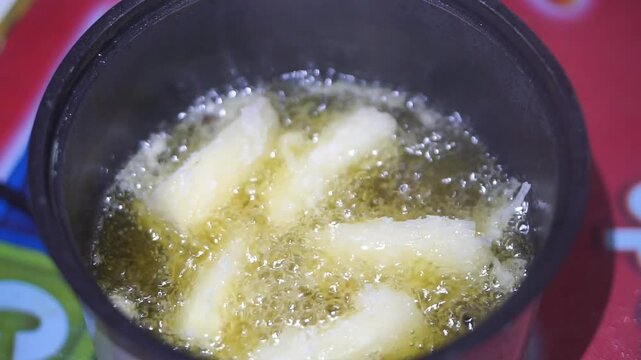 cooking fried cassava in an electric frying pan