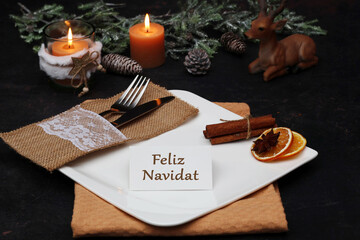 Feliz Navidad: Mesa festiva con platos, cubiertos, adornos navideños y una tarjeta con la...