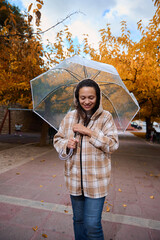 Woman enjoying a walk with umbrella in autumn park