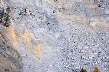 Rockfall at mountain village of Brienz Brinzauls with helicopter and workers hanging on rope in the Swiss Alps on a sunny autumn day. Photo taken November 15th, 2024, Brienz Brinzauls, Switzerland.