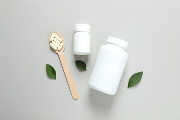 White bottles with pills on gray background