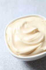 Bowl with mayonnaise and ingredients for cooking on white background