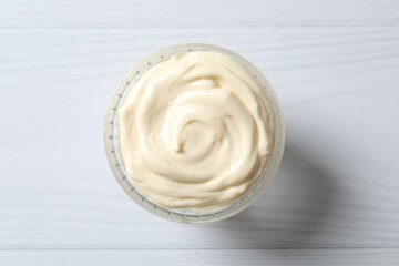 Bowl with mayonnaise and ingredients for cooking on white background