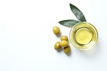 Bowl of fresh olive oil and olives on white background 