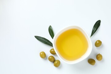 Bowl of fresh olive oil and olives on white background 